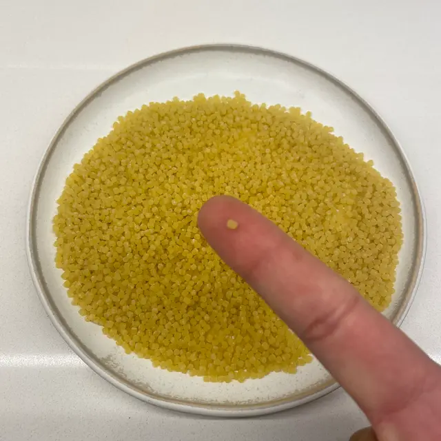 Acini di pepe held between fingers