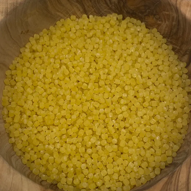 A close up shot of Acini di pepe in a round wooden bowl