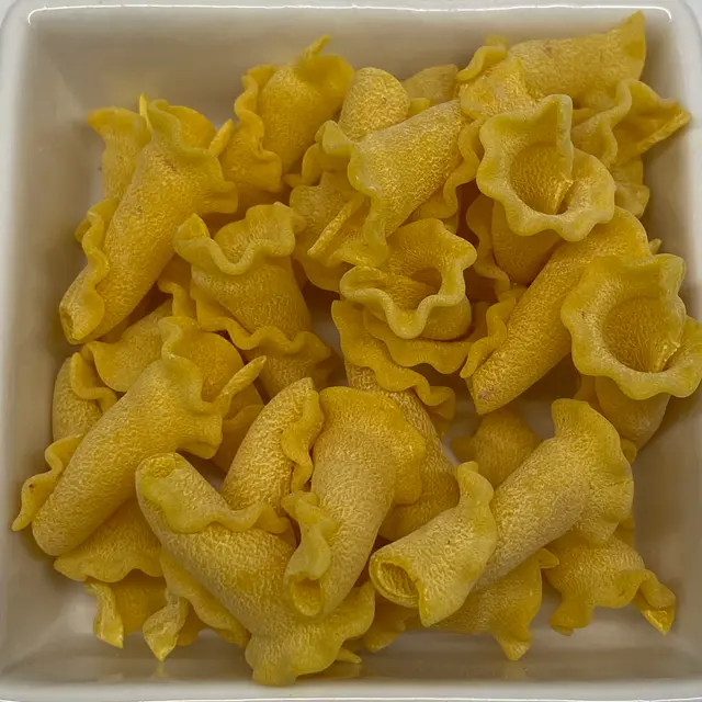 A close up shot of Campanelle in a square white glass bowl