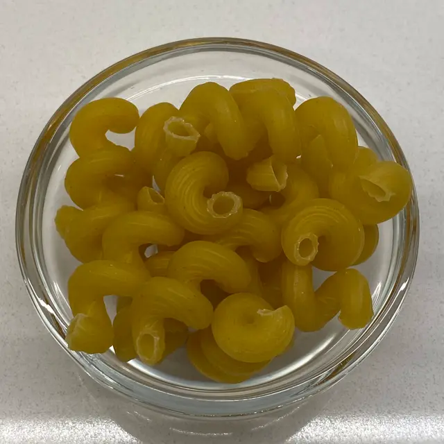 A close up shot of Cavatappi in a small round white glass bowl