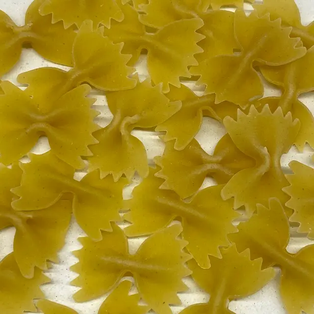 A close up shot of Farfalle on a round white plate