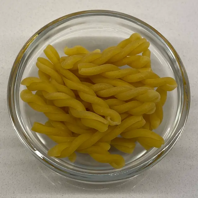 A close up shot of Gemelli in a clear round glass bowl