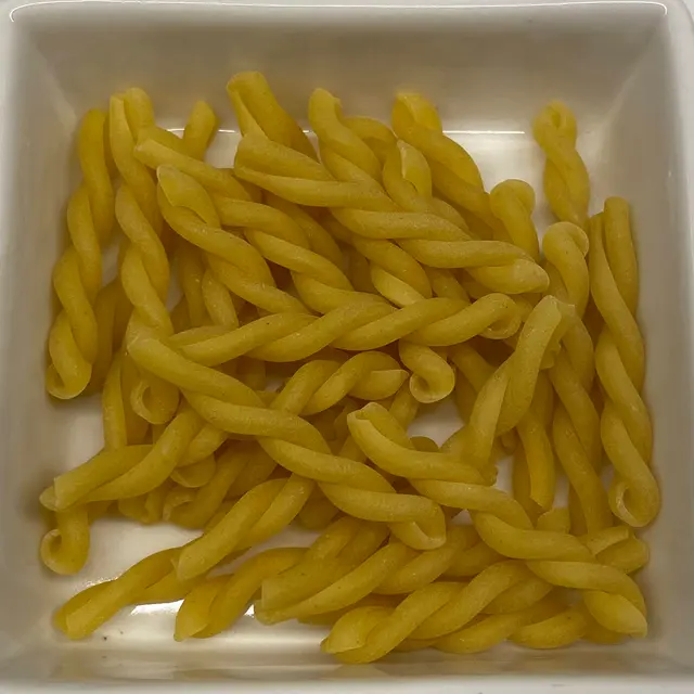 A close up shot of Gemelli in a square white glass bowl