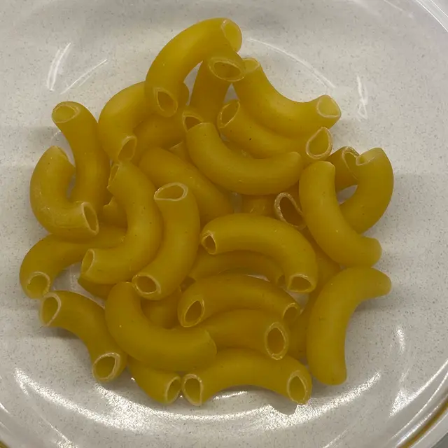 A close up shot of Large Elbow Macaroni on a round white plate