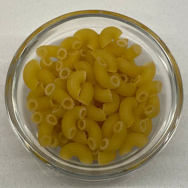 A close up shot of Small Elbow Macaroni in a small round white glass bowl