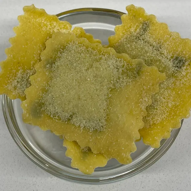A close up shot of Ravioli in a small round white glass bowl