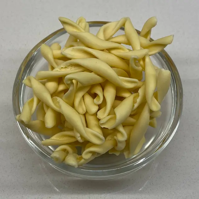 A close up shot of Strozzapreti in a small round white glass bowl