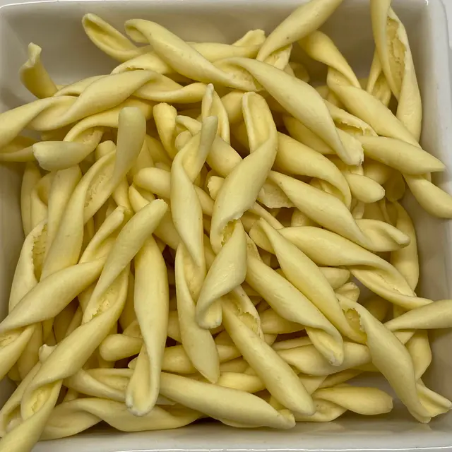 A close up shot of Strozzapreti in a square white glass bowl