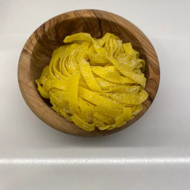 Tagliatelle in a round wooden bowl