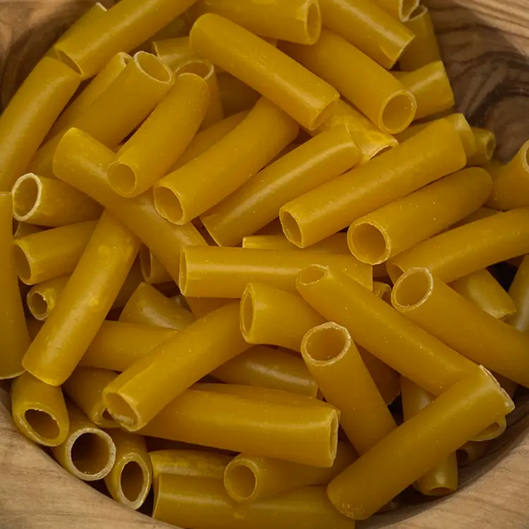 A close up shot of Ziti in a round wooden bowl