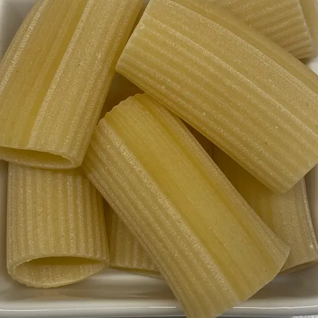 A close up shot of Paccheri in a square white glass bowl