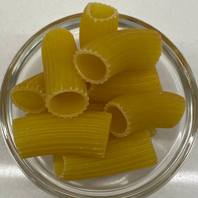 Rigatoni in a small round white glass bowl